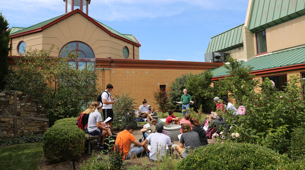 English professor holding class outside in Peace Garden outside of La Roche University's Magdalen Chapel